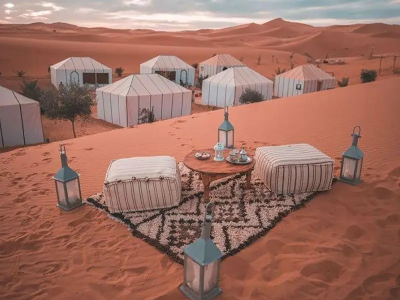 Campamento de lujo con farolillos y jaimas blancas en el Erg Chebbi